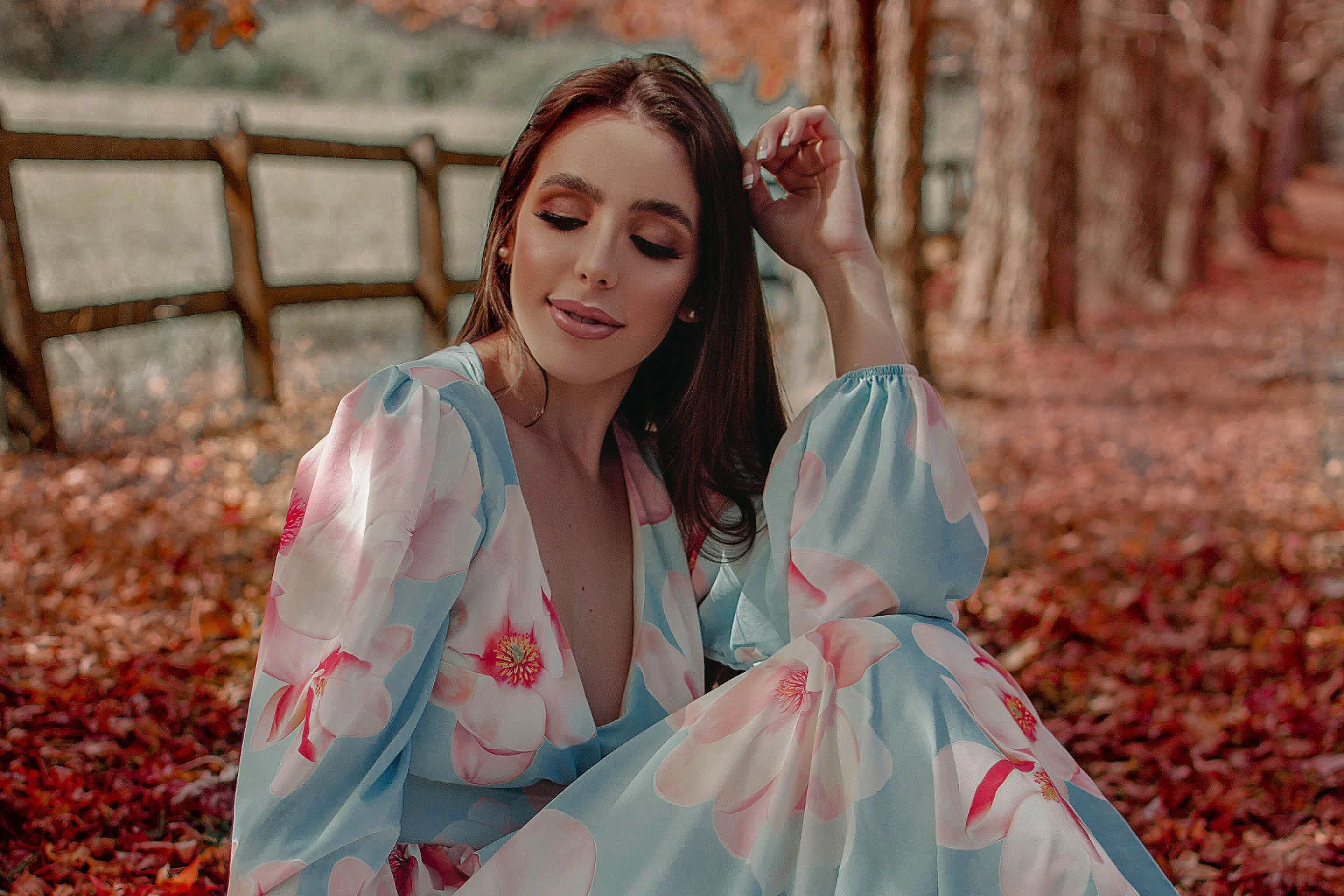 Calm portrait of a woman wearing a floral dress outdoors.